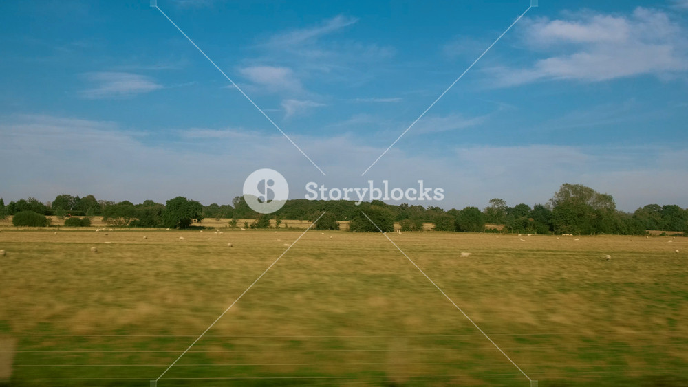 Passenger view of amazing croplands and rolling hills in the Cotswolds in England, UK, an Areas of Outstanding Natural Beauty