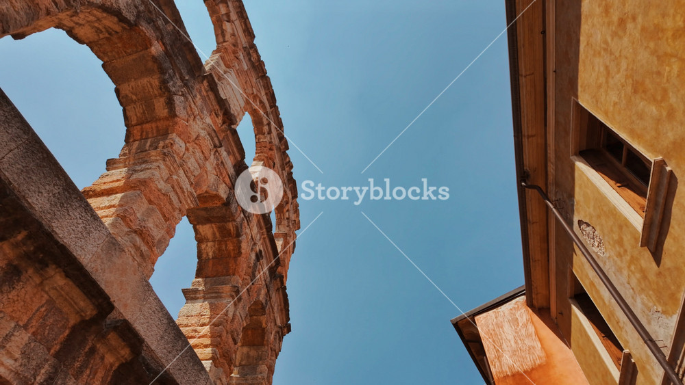 Exterior view of the oval Arena di Verona, Roman arena framed by shadowed corridors and textured stonework, Verona, Veneto, Italy