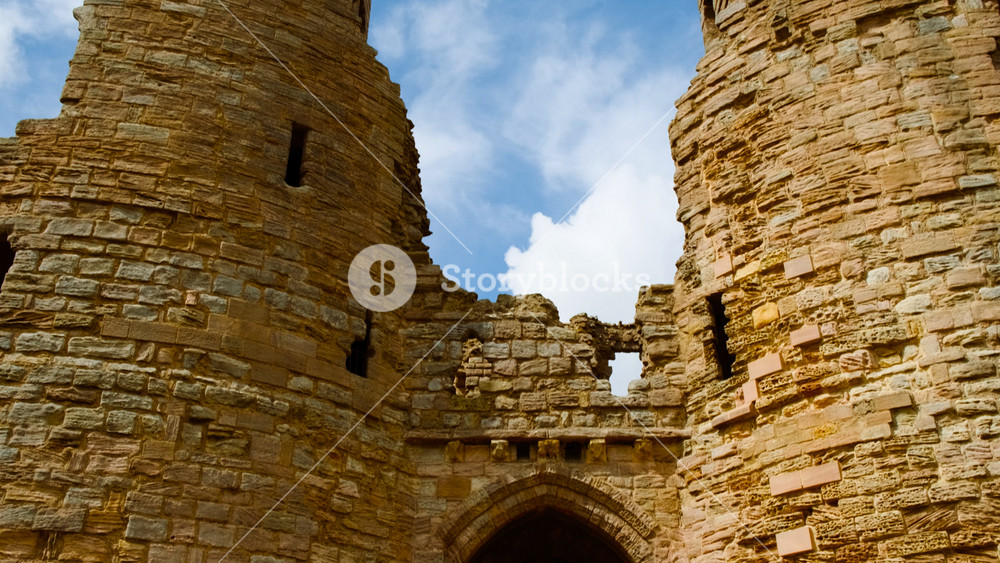 DUNSTANBURGH, United Kingdom, circa 2022 - Establishing shot of Dunstanburgh Castle, a 14th-century fortification on the coast of Northumberland in northern England, UK