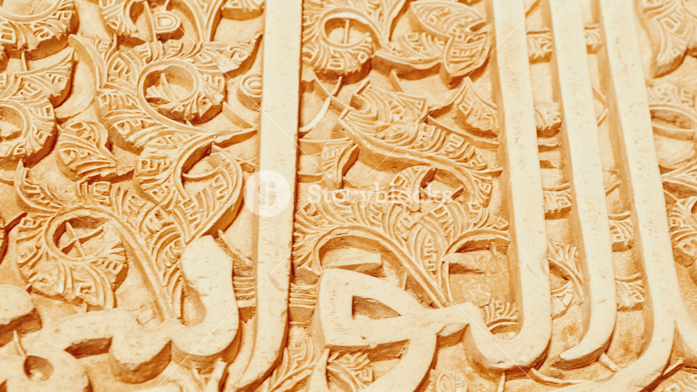 GRANADA, Spain, 23 NOVEMBER 2023 - The Alhambra Palace - Stunning cursive engraved arabesques in the Court of the Myrtles Nasrid Palace in Granada, Anadalucia, Spain