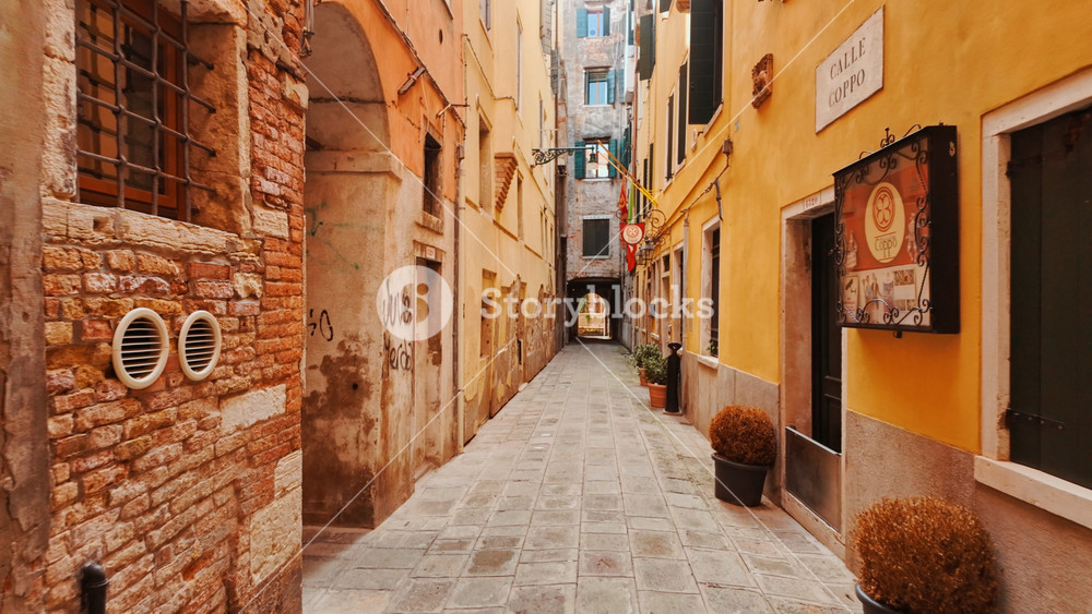VENICE, Italy, 7 November 2024 - Walking along Calle Coppo, Venice, Veneto, Italy, with narrow paving, close facades and quiet doorways