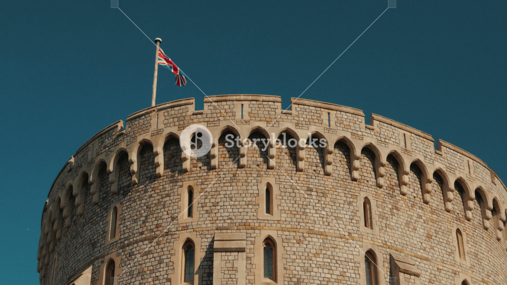 WINDSOR, UK, 19 September 2022 - Close-up detail of the union jack flag flying above the round tower of Windsor Castle in Berkshire, UK