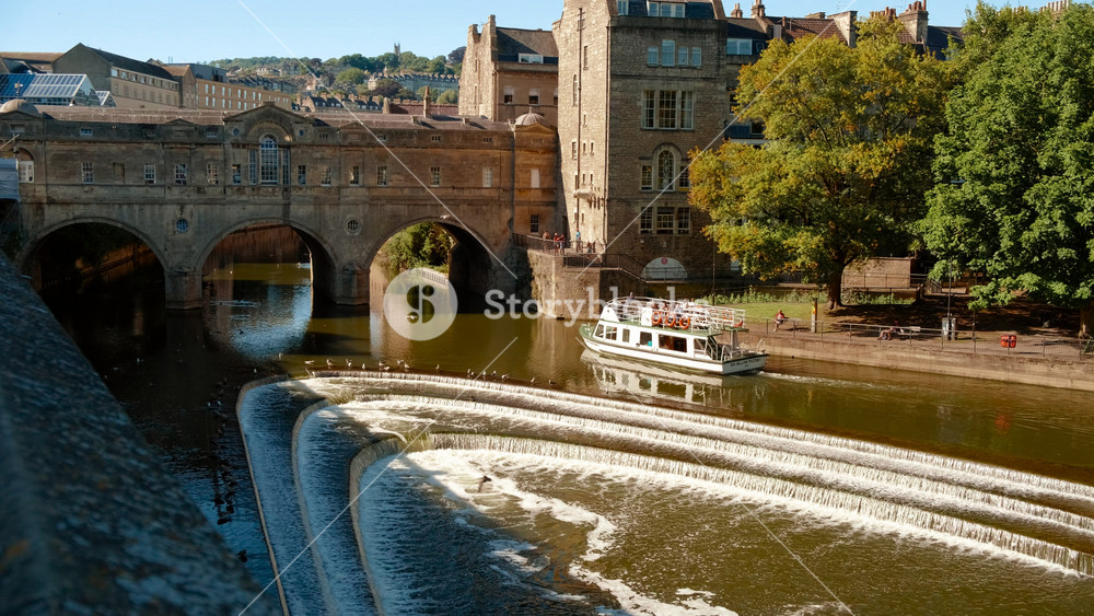 Golden hour view of the Pulteney Bridge crossing the River Avon in Bath, Somerset, England, UK, on a bright sunny day