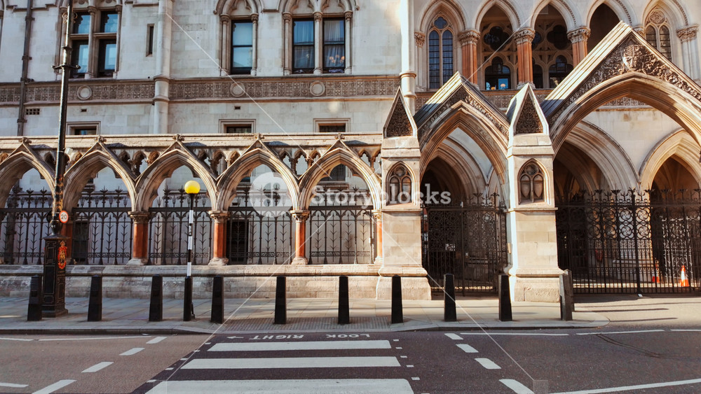 Pedestrian crossing leading to The Royal Courts of Justice, London, England, UK, an ornate Gothic Revival building with grand portals and carved stone