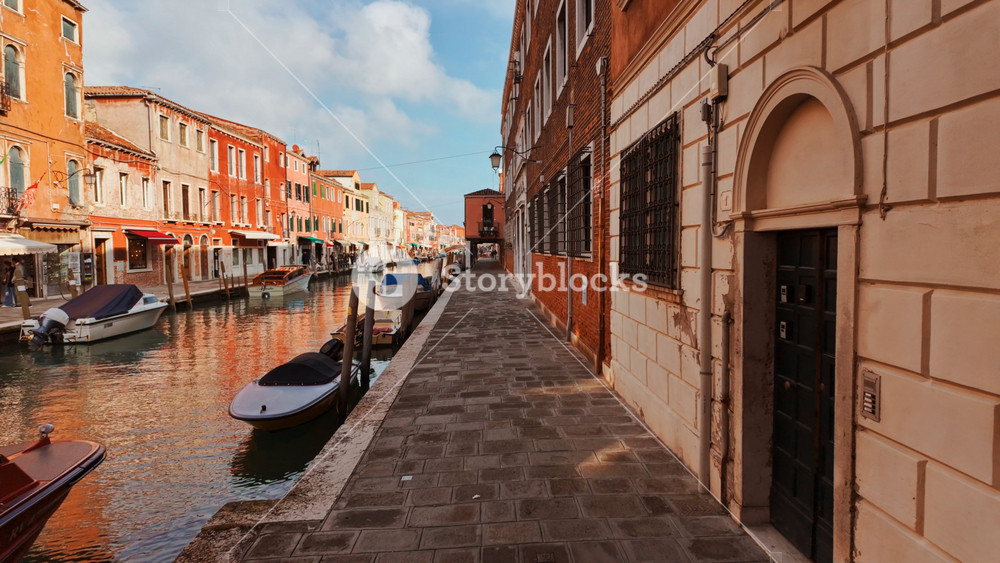 VENICE, Italy, 7 NOVEMBER 2024 - Walking along one of the narrow streets and canals in Murano, Venice, Italy, known for its glass production. Venice has 126 islands linked by 472 bridges