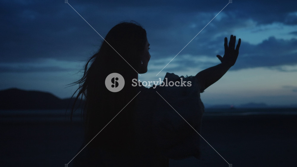 Woman finding inner peace in nature. Silhouette of young woman standing in beautiful natural landscape with mountains, opening her arms and