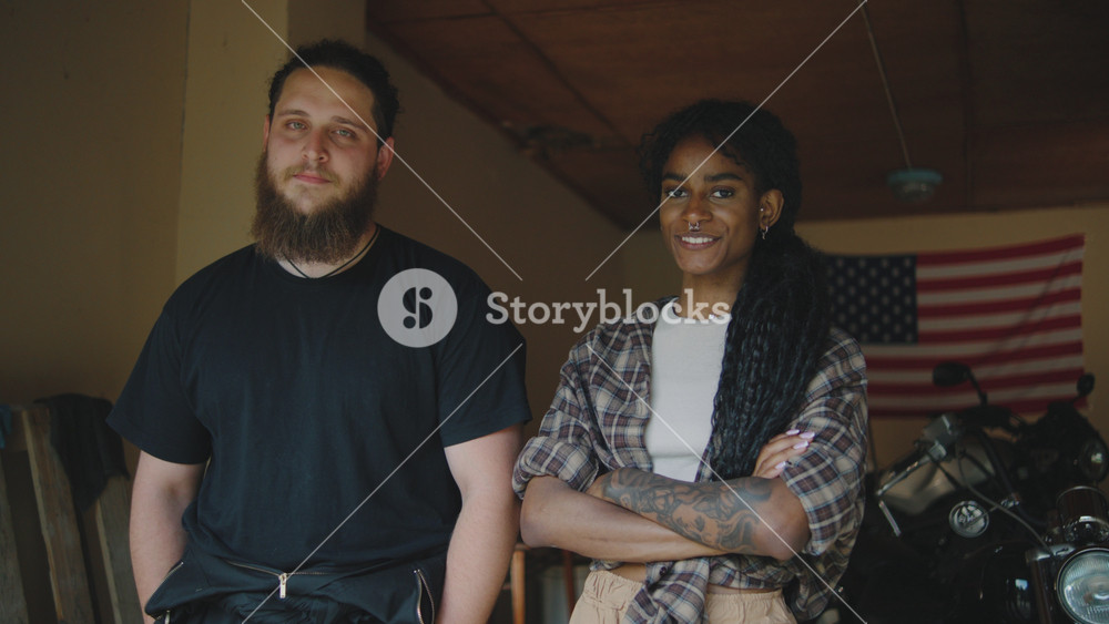 Young adults standing together in a garage with motorcycles, showcasing a sense of friendship and lifestyle in a relaxed environment