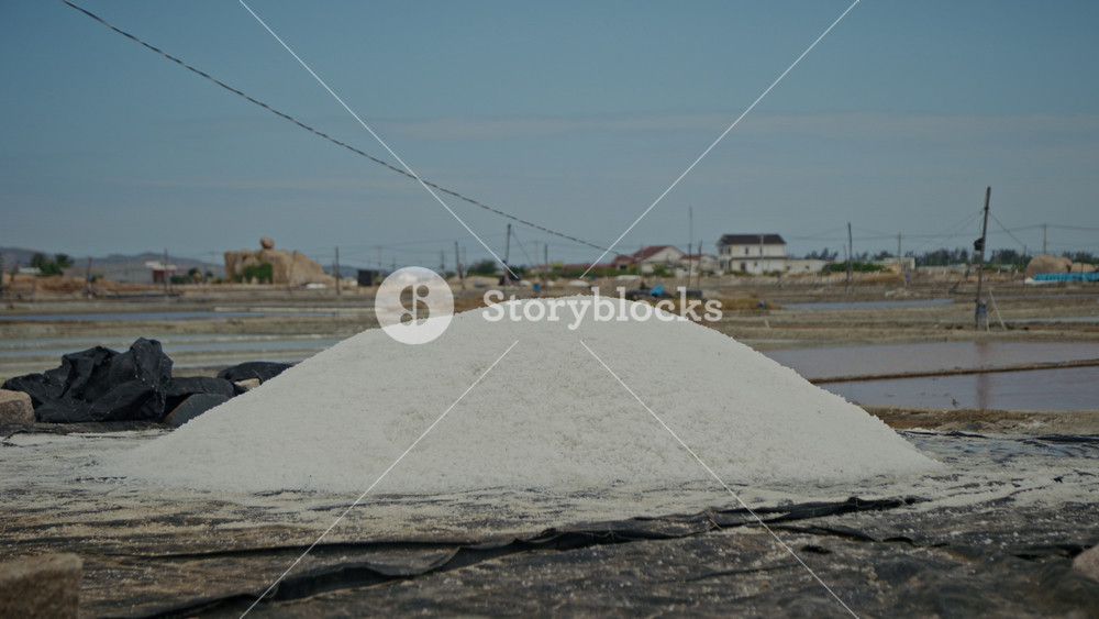 High dried salt pile placed near solar evaporation ponds at farm. Traditional method of salty food condiment extraction at Vietnam