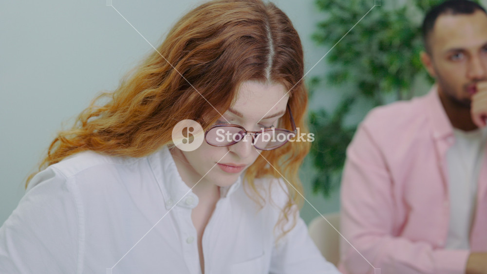 Attractive Woman Team Member Noting Information on the Business Meeting in Office. Young Lady Calculating Business Plan and Conducting