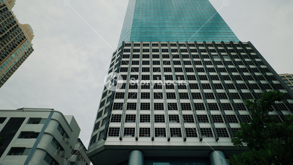 A low-angle view of towering with and steel facades in a city business district. Symbol of economic growth, corporate power, and modern