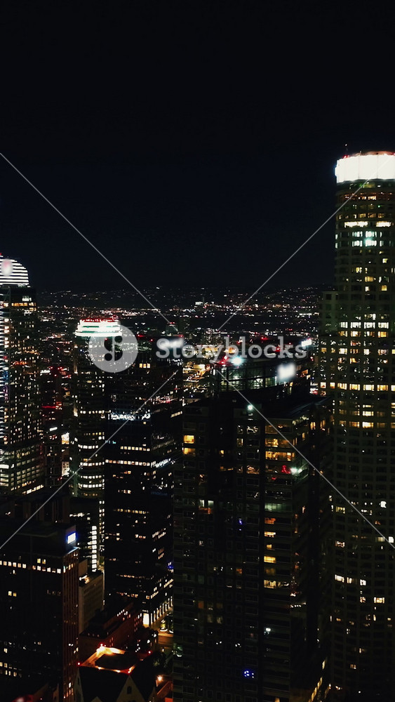Experience a stunning aerial view of Los Angeles at night showcasing the city's vibrant skyline and illuminated buildings from above