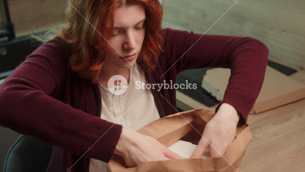 Caucasian woman girl female unpacking food delivery paper bag taking out order boxes from package ready to eating delivered meal cafe