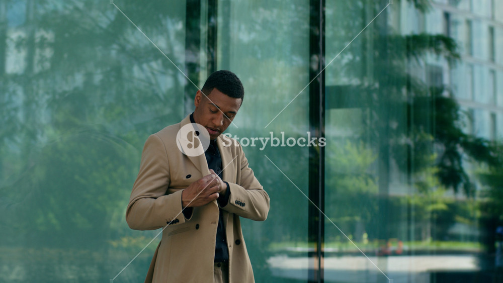 Cool rich African American business man walk city outdoors office building male employer CEO businessman putting on stylish sunglasses