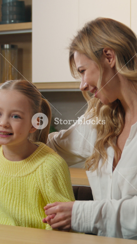 Caucasian happy family dancing at kitchen carefree playful child girl with mother at dining table in kitchen having fun together mom holding