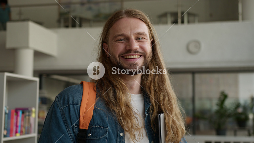 Portrait Caucasian student guy man male positive carefree in university college academy hallway corridor holding laptop smiling happy