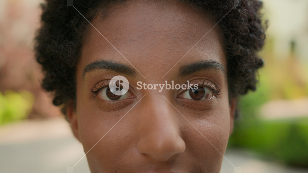 Extreme close up female face cropped African American ethnic girl woman young healthy lady close-up looking at camera eye problem eyes laser