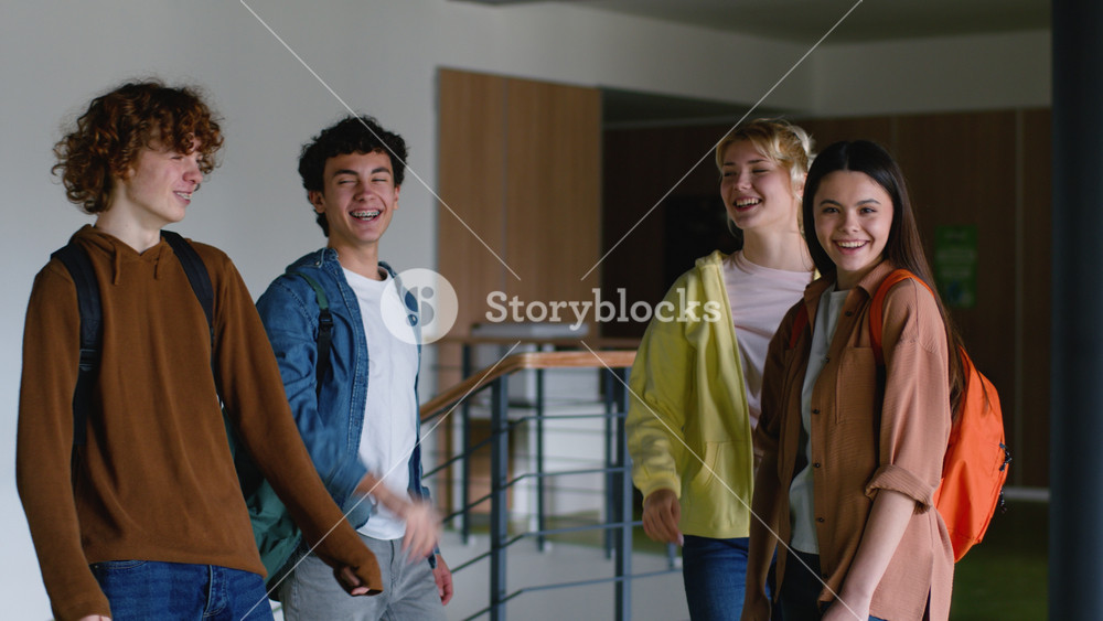 Caucasian students girls guys in high school stack hands unity friendship team happy women females friends schoolgirls boys males men