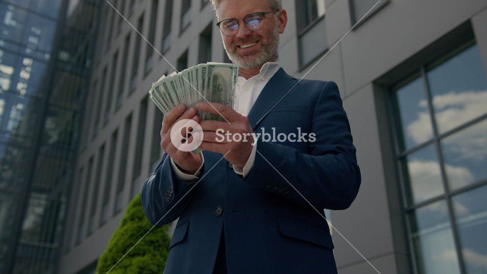Excited lucky winner wealthy happy rich old middle-aged businessman hold money cash celebrate financial achievement outdoor mature senior