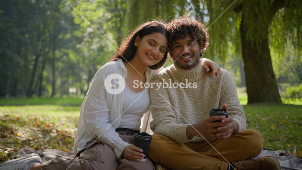 Happy smiling multiethnic couple in love african american indian man woman having picnic on blanket park outdoors boyfriend girlfriend guy