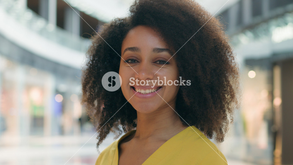 African American woman turn head looking at camera smiling friendly happy cheerful pleasure female girl glad delighted shopping mall lady