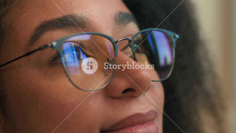 Close up female face woman African American girl in eyeglasses looking away glasses reflection smile calm gen z ethnic student business lady