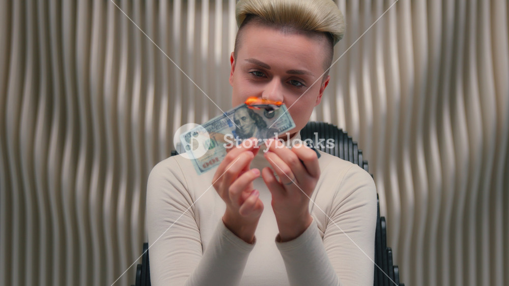 Caucasian female woman girl burning paper money with fire flame laughing in white futuristic studio lady laugh burn banknote cash finance