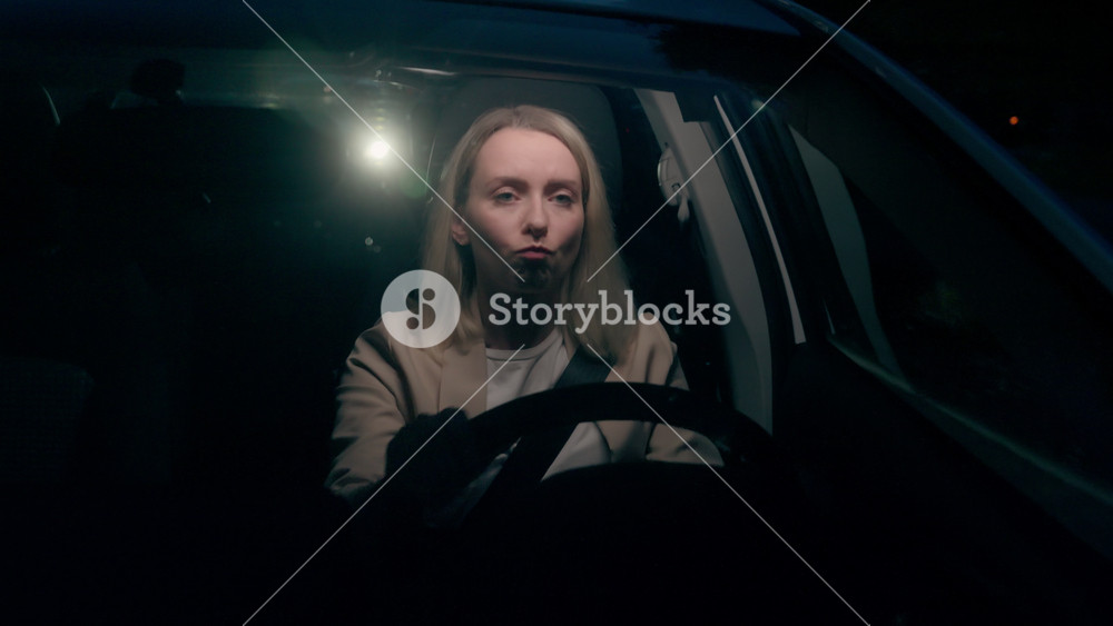 Worried stressed Caucasian anxious woman female girl automobile driver driving auto car nervous tapping fingers on steering wheel rushing