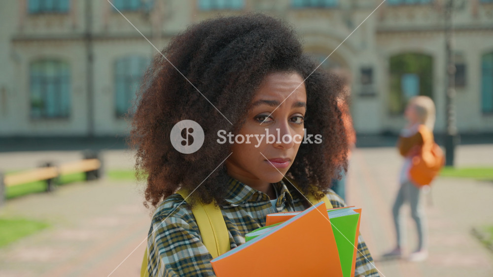 Sad upset African woman student hold books couple talking background bullying frustrated girl education high school university college