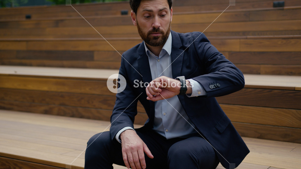 Nervous anxious Caucasian business man middle-aged guy businessman wait on stairs outdoors impatient upset sad male in city waiting meeting