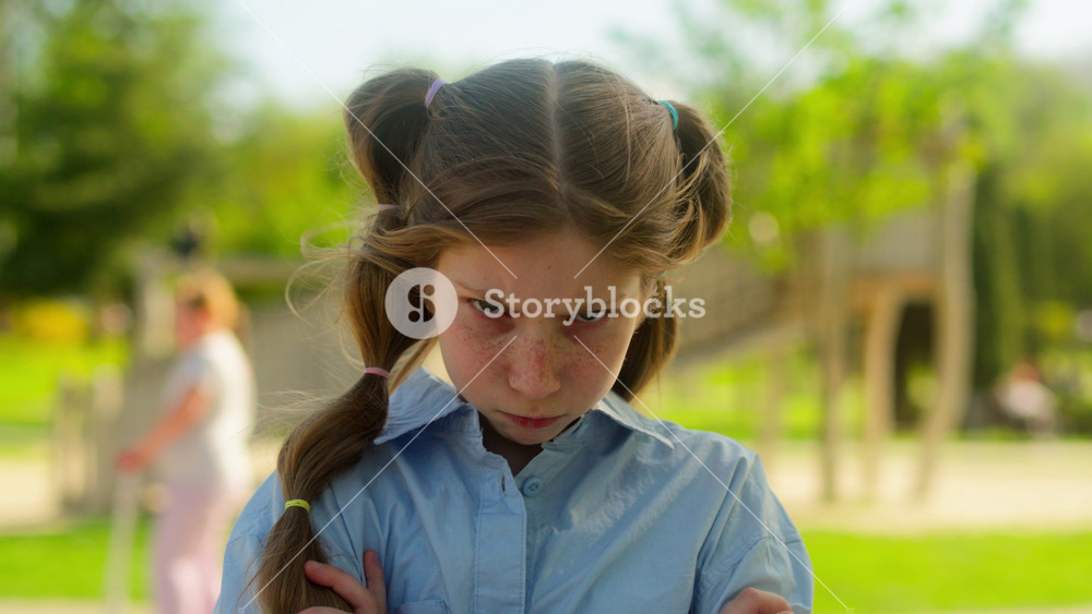 Portrait little girl angry frowning offended sad annoyed naughty Caucasian child school kid schoolgirl daughter family adopted children
