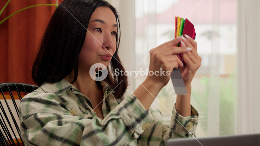 Asian Korean Chinese Japanese woman designer freelancer female girl indoor businesswoman shopping choosing color holding paper document