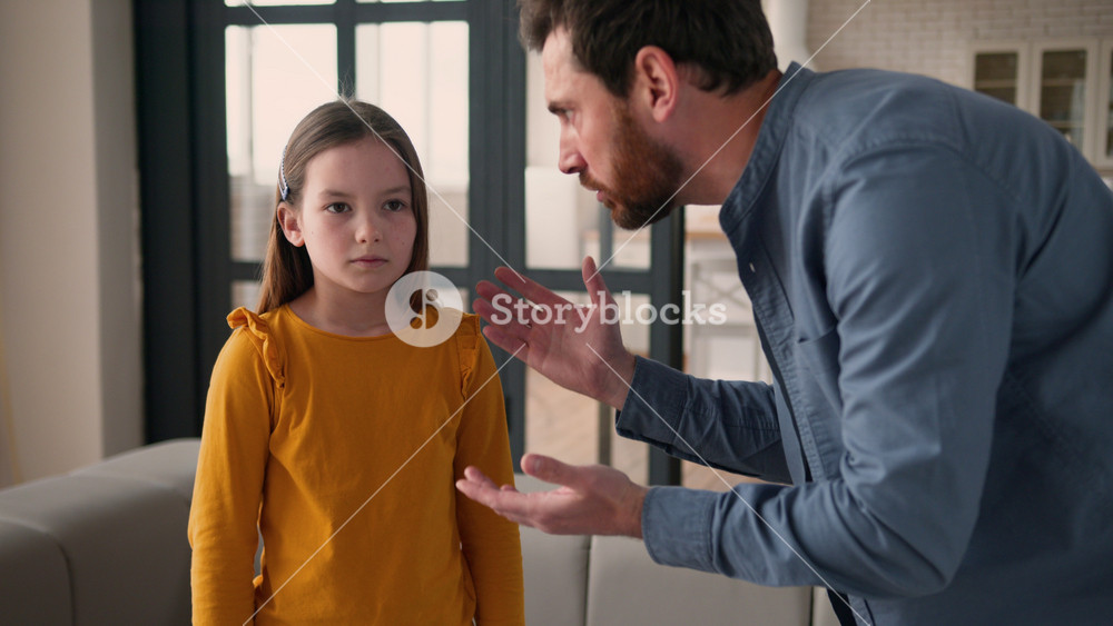 Angry stressed irritated Caucasian guy scold anxious rebellious kid little child schoolgirl man dad male scream at daughter girl at home