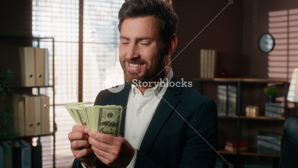 Mature smiling Caucasian business man counting dollars money kiss cash enjoying financial reward prize wealthy European middle-aged