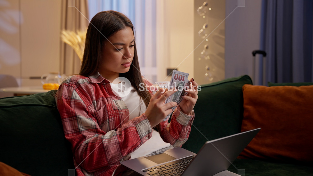 Concentrated girl Caucasian female successful business woman freelancer at home night count dollars currency cash salary online betting