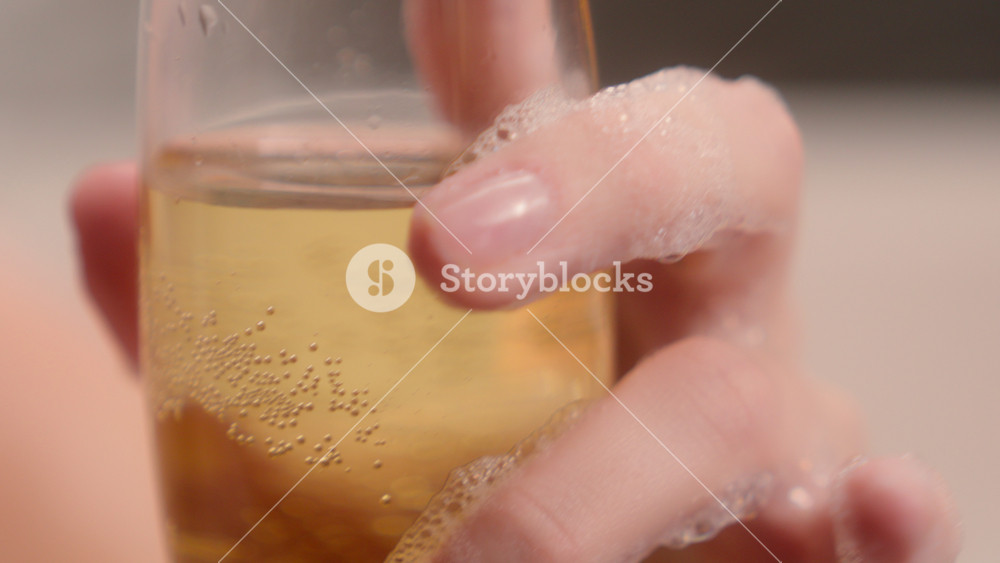 Close up cropped view relaxing sensual Caucasian relaxed drunk woman female girl lady in spa bathing washing foam at home holding glass of