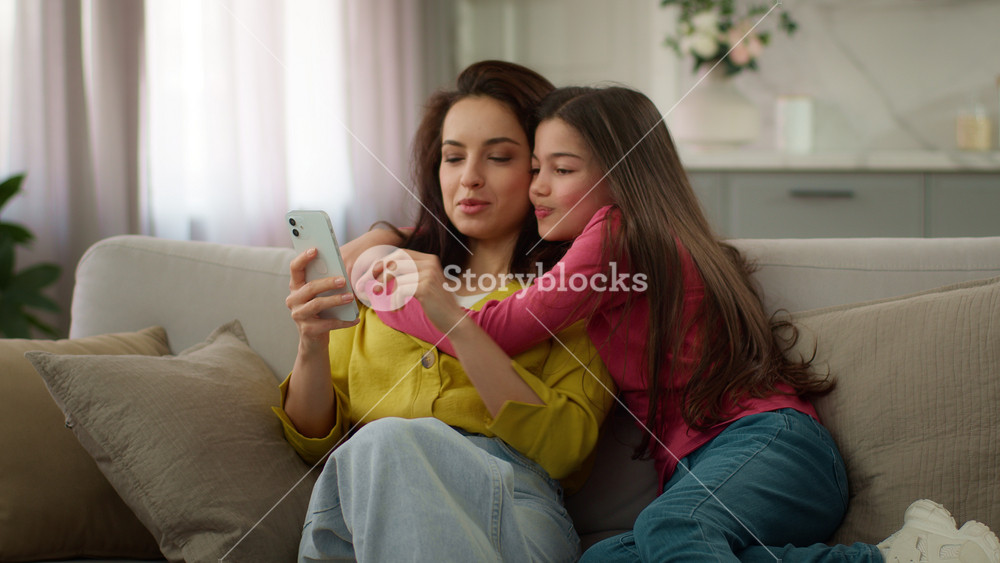 Happy family spending weekend together. Caucasian woman female mother using mobile cell phone online app active little girl child kid