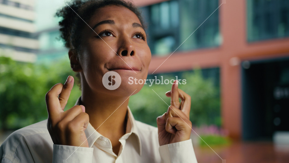 African American woman female girl businesswoman portrait crossed fingers hope dream wish gesture hopeful pray wishing waiting results