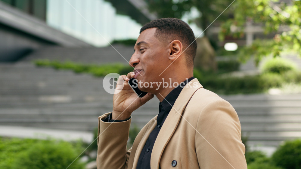 Happy African American ethnic business man employer businessman guy male entrepreneur investor leader manager smiling talking mobile phone