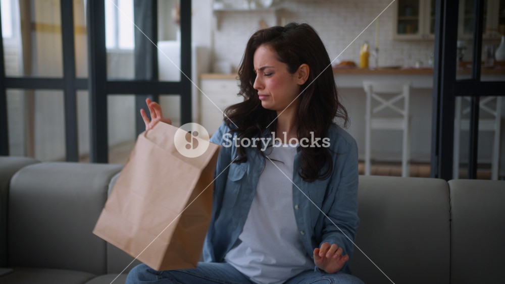 Caucasian woman hungry girl female at home couch sofa unpack open paper bag package food delivery cafe order meal spoiled stink odor bad