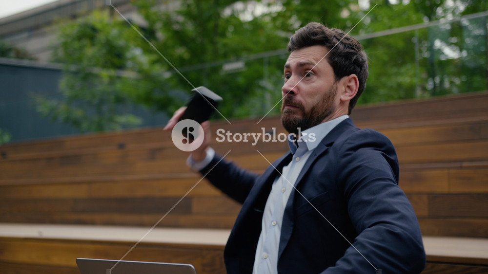 Annoyed mad angry man Caucasian businessman furious business leader work remote laptop city outdoors male guy talk mobile phone quarrel