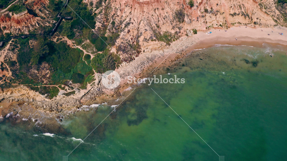 Aerial drone view Algarve Portugal traveling resort holiday retreat recreation red hills beach Atlantic Ocean blue green water coastal