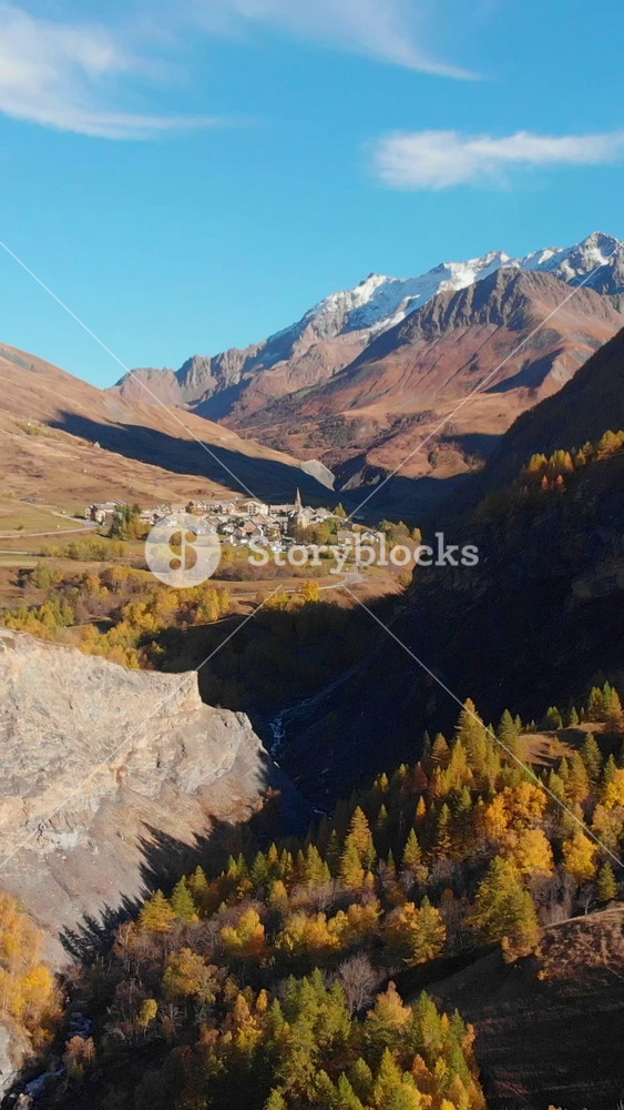 Vertical Aerial Of Colorful Mountain And Forest Landscape With A Small Village In The French Alps In Autumn Fall