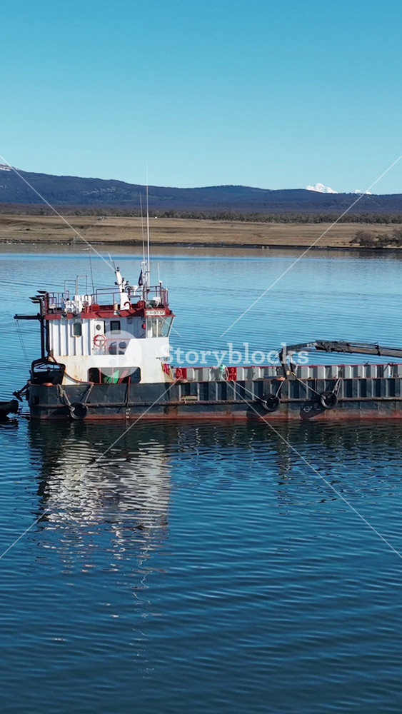 Puerto Natales, Antarctica, Chile - 1.5.2026 - Moored Boat At Puerto Natales In Antarctica Chile. Sunny Day. Birds Eye View Of Stunning Dark River And Forest Trees.
