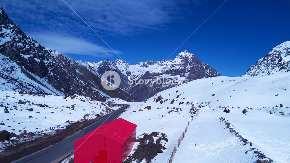 Red Shed In Andes Mountains Santiago Chile. Aerial View Of A Ski Resort Nestled In The Snowy Mountains. Snowflakes Tourism Swiss Alps Snow Capped. Snowflakes Glacier. Andes Mountains Santiago.