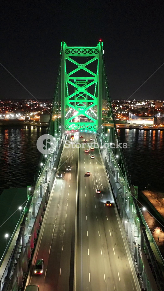 Benjamin Franklin Bridge In Philadelphia Pennsylvania United States. Birds Eye View Of Suspension Bridge With Cars Driving Across. Night Avenue Downtown Cityscape. Night Downtown Panorama.