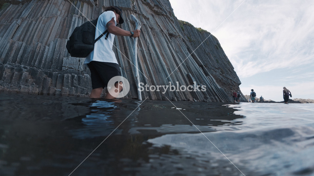 Underwater footage of the hiker walking barefoot on the shallow area near the Cape Stolbchaty on coast of Kunashir Island, Russia