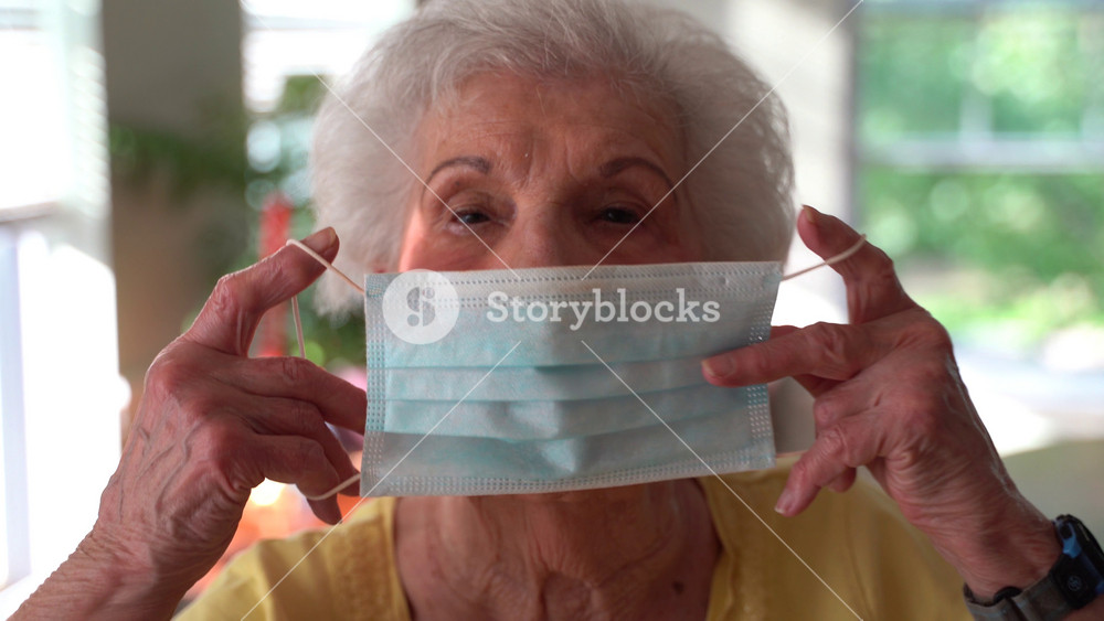 Extreme closeup portrait of elderly woman putting on medical face mask protection. Quarantine coronavirus covid-19 for old people. Retirement Health at Risk, granny in mask