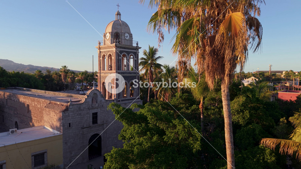 View stunning aerial shots of the Loreto Mission church at sunset in Baja California Sur, Mexico. Experience this desert oasis