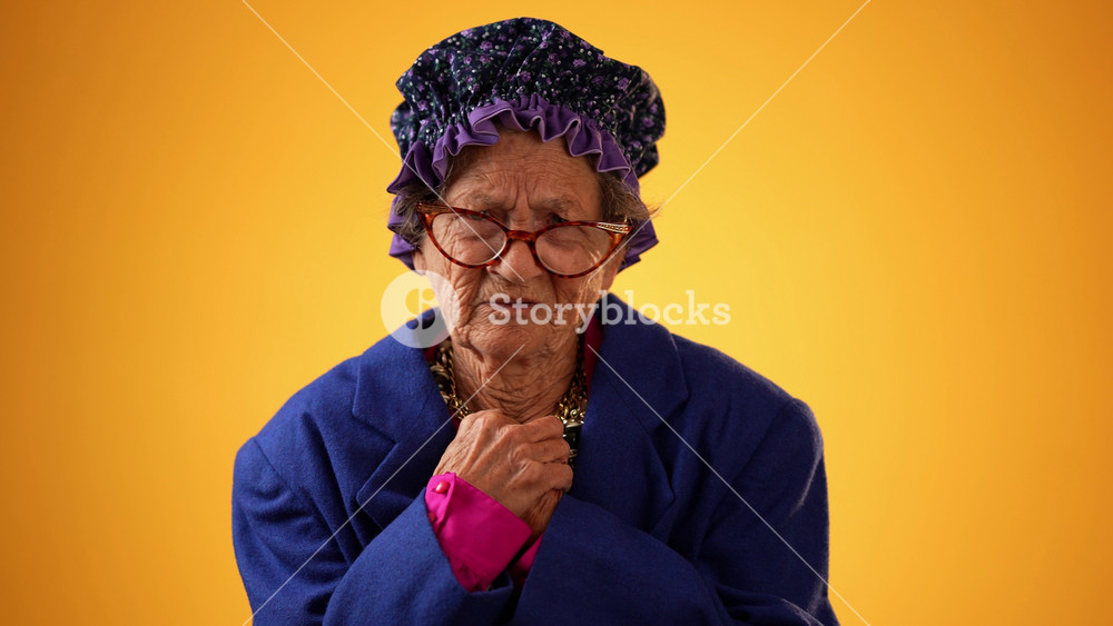 Funny portrait of smiling happy elderly toothless senior old woman with wrinkled skin, pointing fingers herself ask say who me, smiling talking and pointing. Isolated on yellow background.