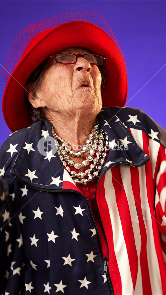 Vertical video of puzzled, shocked, funny crazy toothless grandmother mature woman, 80s, acting wearing US flag jacket isolated on purple background. Concept of concern winner.
